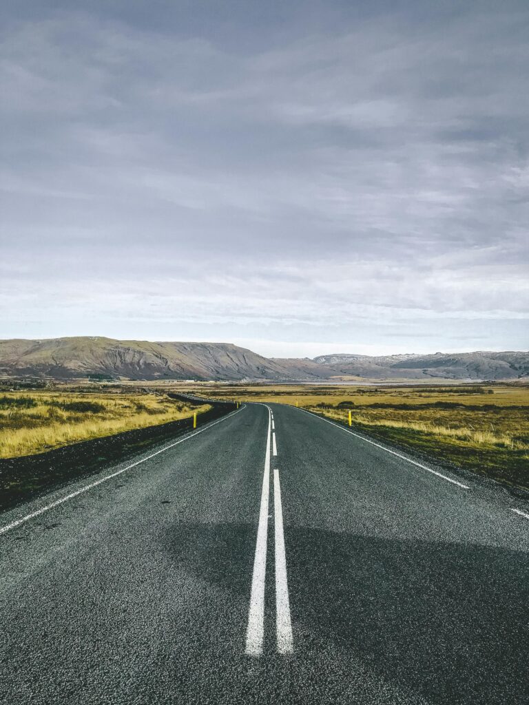 pexels-photo-2364401-2364401 A straight road leading through the picturesque landscapes of Iceland's countryside under a cloudy sky.